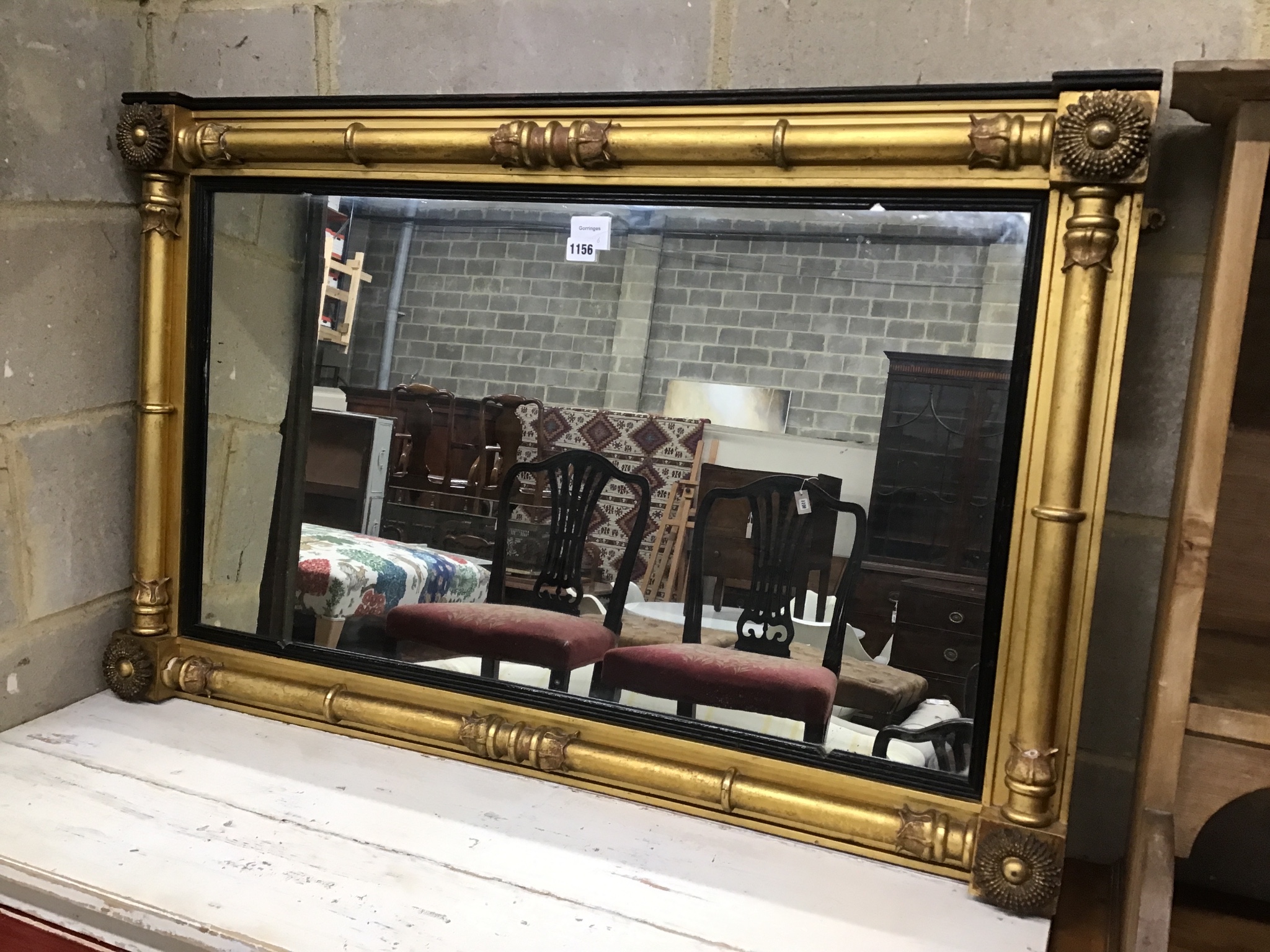 A William IV giltwood and composition overmantel mirror with ebonized slip width 106cms, height 68cms.